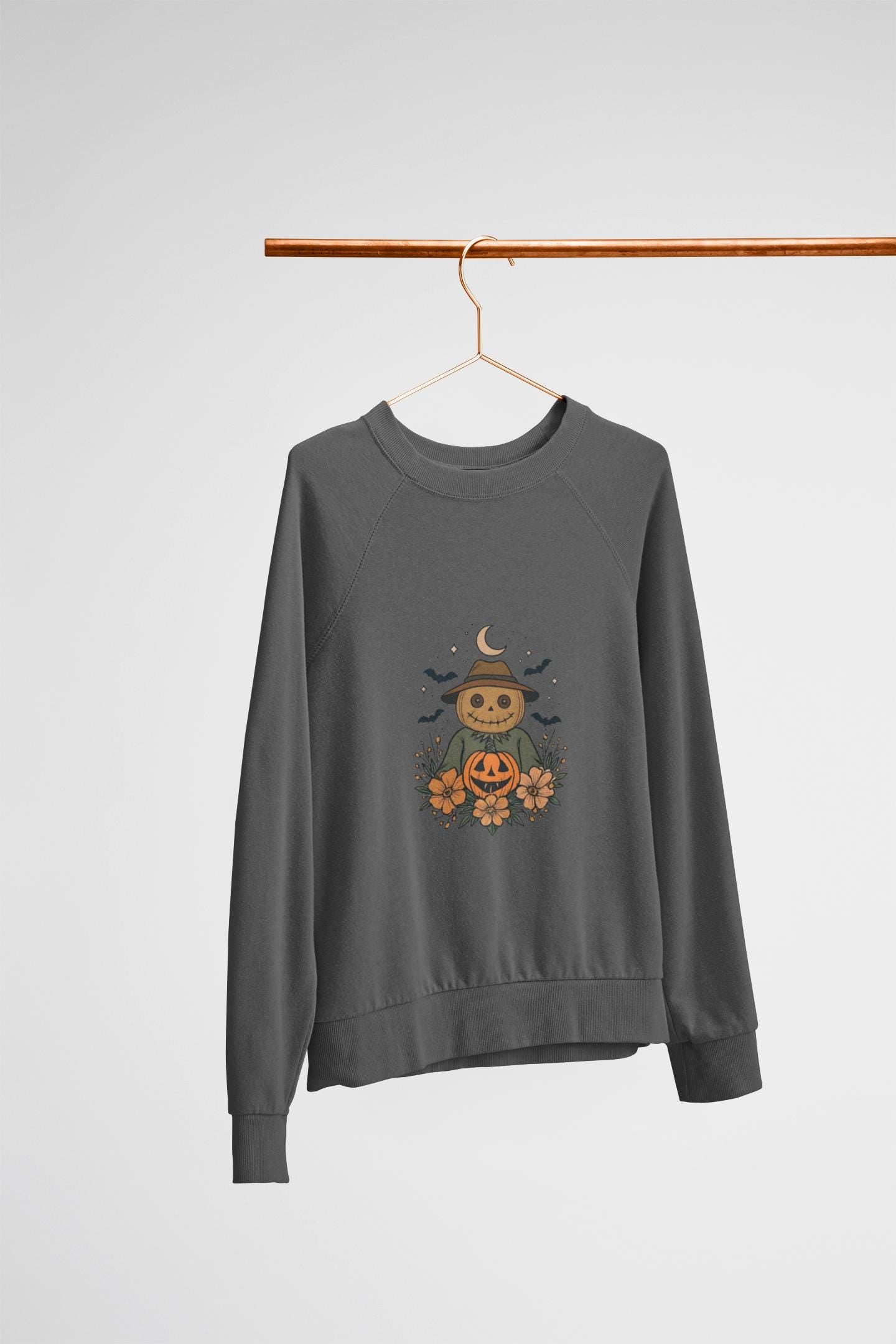 Cozy Halloween Sweatshirt with Scarecrow Design, The playful design featuring a whimsical scarecrow and autumnal elements creates a cheerful vibe, perfect for adding a festive touch to your wardrobe.