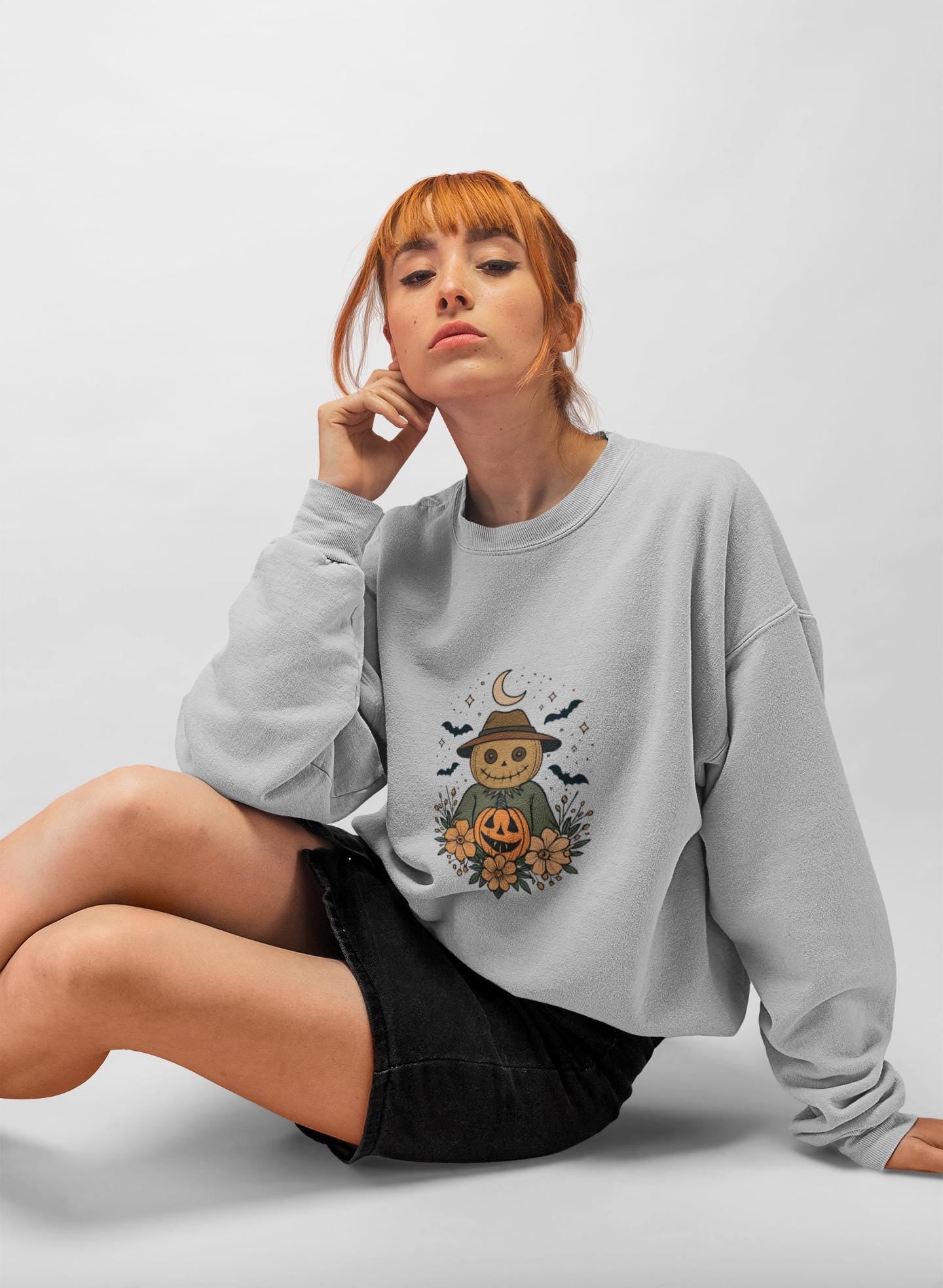 Cozy Halloween Sweatshirt with Scarecrow Design, The playful design featuring a whimsical scarecrow and autumnal elements creates a cheerful vibe, perfect for adding a festive touch to your wardrobe.