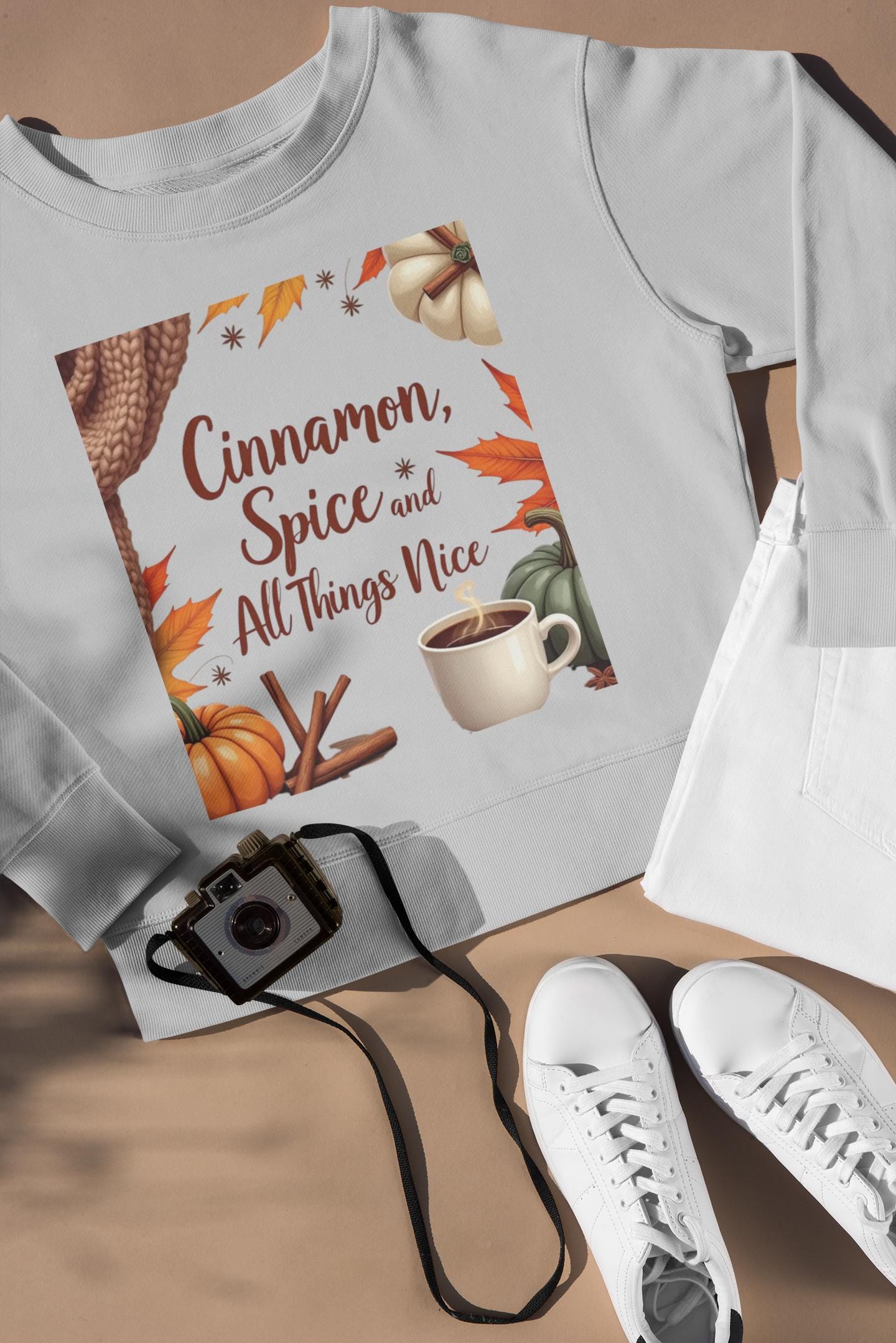 Cinnamon Spice and All Things Nice Sweatshirt, promises to keep you snug while adding a touch of seasonal charm to your wardrobe. Whether you’re sipping on a pumpkin latte or taking a leisurely stroll through fallen leaves,